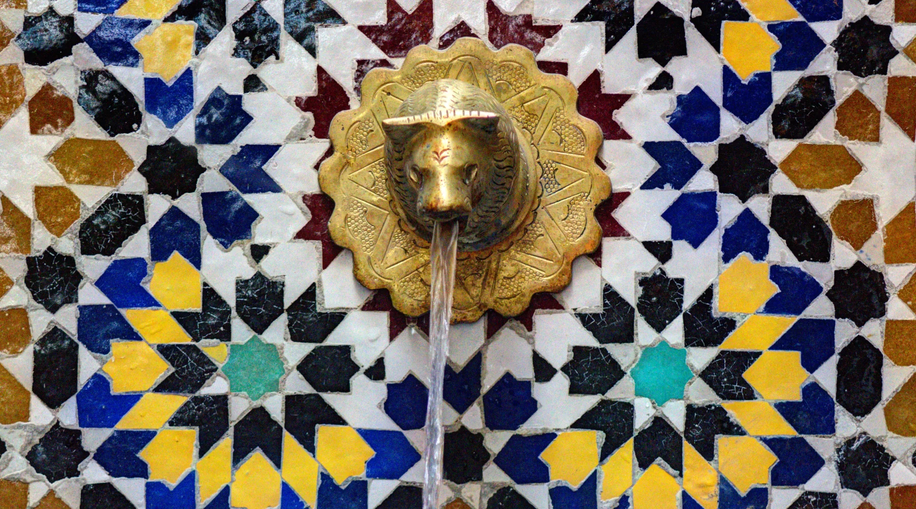 Moroccan zellige on fountain with brass tap